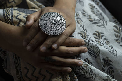 Close-up of woman holding hands on bed at home