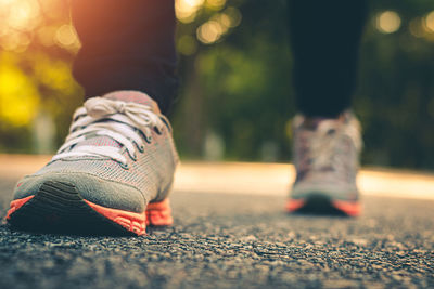 Low section of person wearing shoes on street