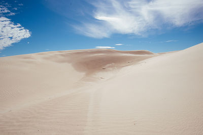 Sand dunes in desert against sky