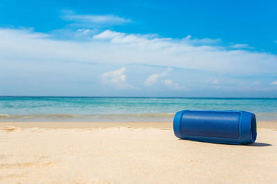 Deck chairs on beach against blue sky