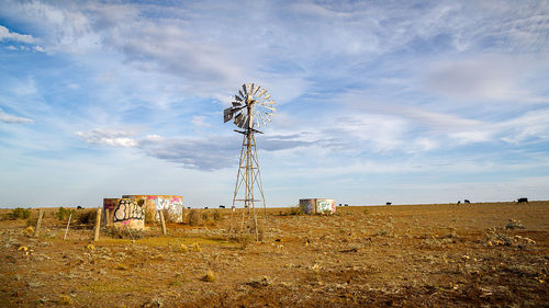Traditional windmill on field against sky