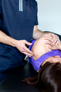 Physiotherapist working on patient's shoulder injury treatment.
