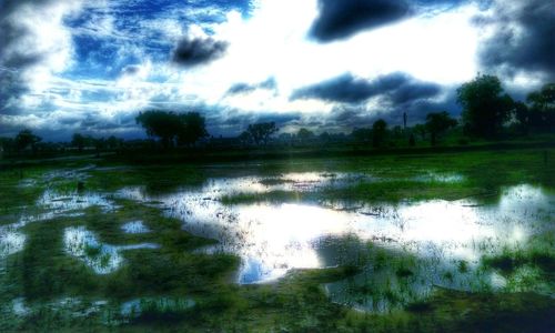 Scenic view of lake against cloudy sky