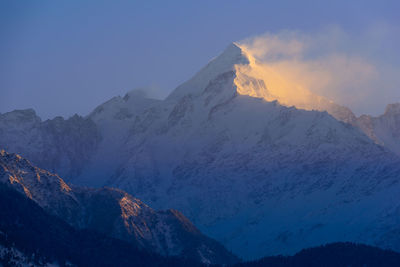 Scenic view of snowcapped mountains against sky during sunset