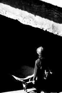 Rear view of man sitting on table