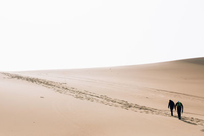 Two men standing on desert 