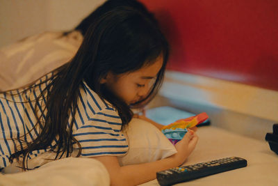 Side view of girl playing with toy at home