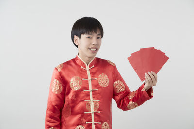 Portrait of smiling boy standing against white background