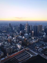 Aerial view of modern cityscape against sky during sunset