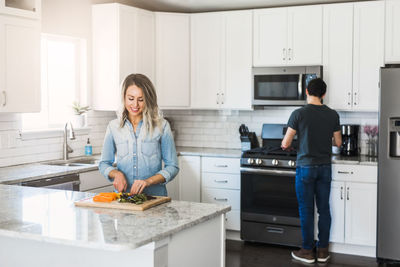 Man and woman standing in kitchen at home