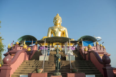 Low angle view of statue against building against sky