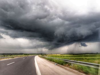 Road passing through landscape during rainy season