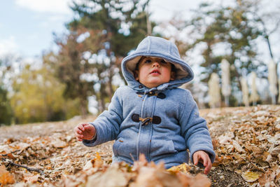 Cute boy sitting on land