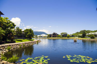 Scenic view of lake by building against blue sky