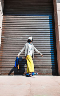 Woman standing against shutter