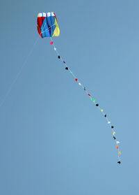 Low angle view of balloons against clear blue sky