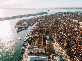 High angle view of city by sea against sky