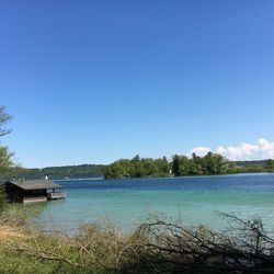 Scenic view of calm lake against blue sky