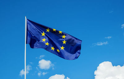 Low angle view of flag against blue sky