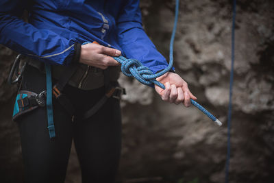 Midsection of woman preparing for rock climbing