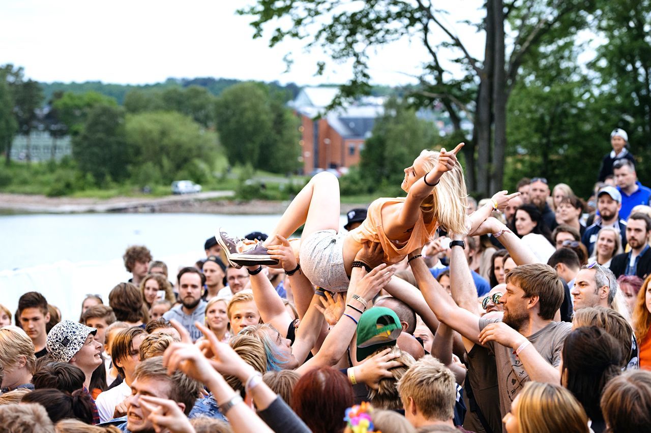 large group of people, lifestyles, person, leisure activity, men, crowd, togetherness, enjoyment, fun, relaxation, mixed age range, vacations, water, sitting, tree, tourist, enjoying, crowded, outdoors