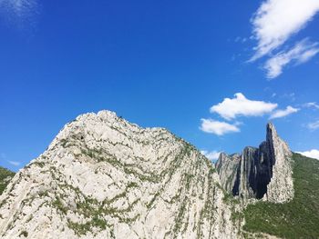 Low angle view of mountain against blue sky