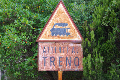 Close-up of information sign against trees