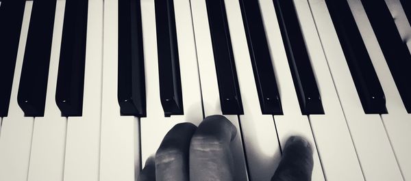 Cropped hand of person playing piano