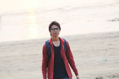 Portrait of young man standing at beach