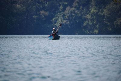 Man rowing boat in sea