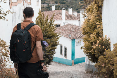 Rear view of man standing outside house