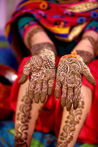 Low section of woman with tattoo on hands