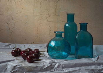 Close-up of wine bottles on table against wall