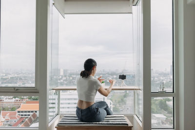 Rear view of man looking through window