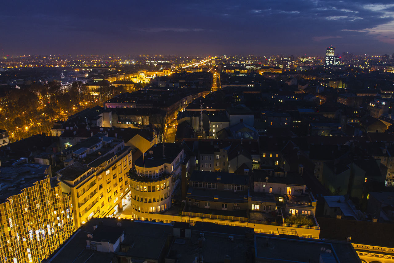 HIGH ANGLE SHOT OF ILLUMINATED CITYSCAPE AGAINST SKY