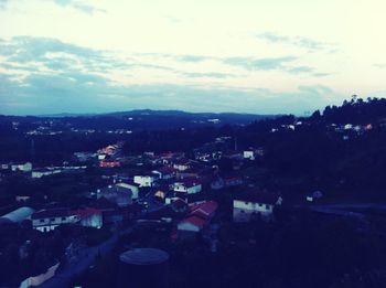 View of cityscape against cloudy sky