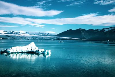 Scenic view of glacier on sea against sky