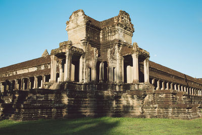 Low angle view of old temple against clear blue sky during sunny day