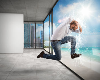 Young man jumping on glass floor