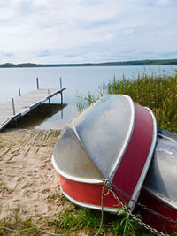 Boat moored on beach against sky