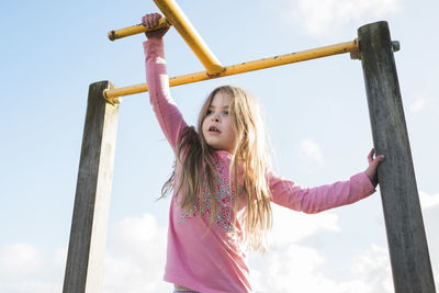 Young girl on playground equipment at the park