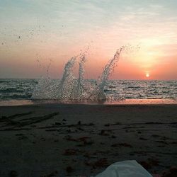 Close-up of beach against sky during sunset