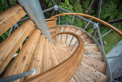 Downward view of spiraling wood stair case outdoor forest background