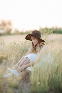 Woman wearing hat on field against clear sky