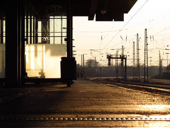 Railroad platform by tracks during sunset