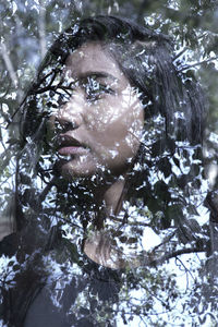 Double exposure image of thoughtful young woman and trees