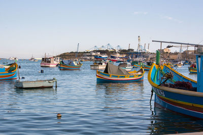 Boats moored in sea against clear sky