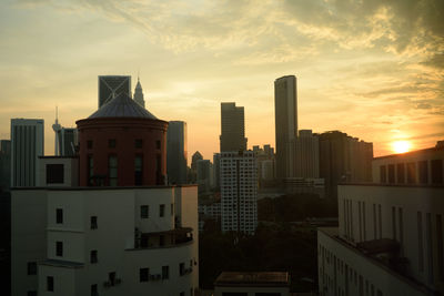 Buildings in city against sky during sunset