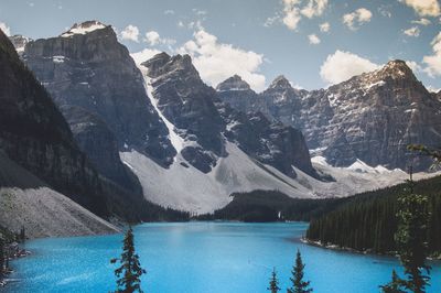 Scenic view of lake by mountains against sky