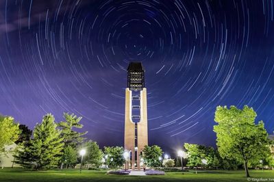 Low angle view of illuminated tower against sky at night